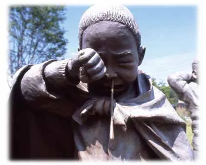 Bronze of a boy crying with his face in his hands