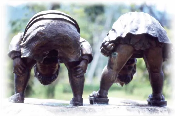 Bronze sculpture of two children peeking out between their legs