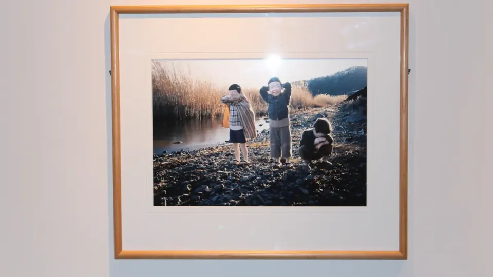 白い壁に掛けた、水辺のこどもたちの写真パネル