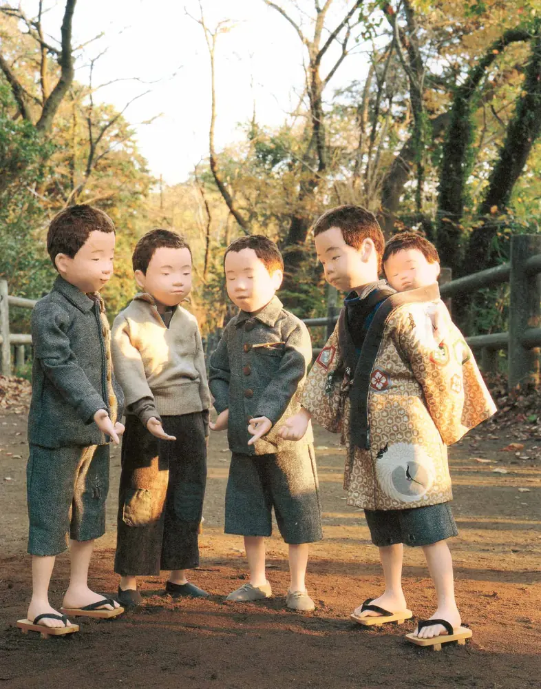 輪になってじゃんけんをする男の子たちと、赤ちゃんを背負った子の人形