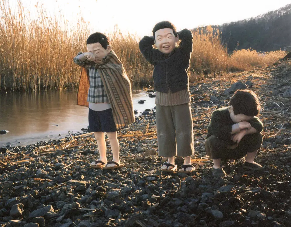 川べりで、泣く子と笑う子と、うずくまる子の、三人の男の子の人形