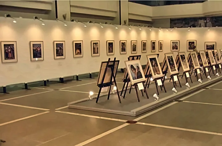 展示会場の白い壁に並べて掛けた写真パネルと、床の台の上に三脚で並べた写真パネル