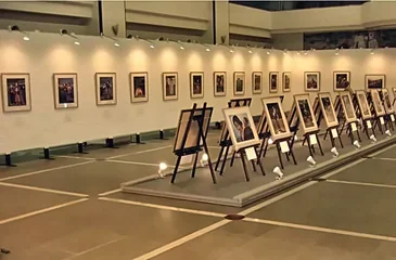 展示会場の白い壁に並べて掛けた写真パネルと、床の台の上に三脚で並べた写真パネル