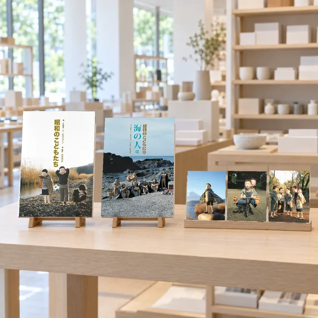 明るいミュージアムショップの台に、本立てに立てた写真集2冊と、ポストカード3枚(イメージ)