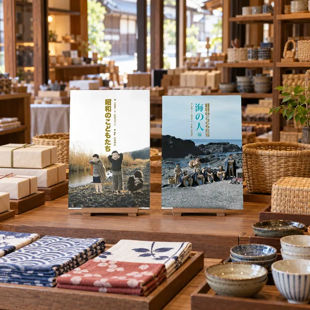 お土産売り場の棚に、手ぬぐいや器と並べて本立てに立てた写真集2冊(イメージ)